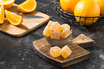 Marmalade sprinkled with sugar in a bowl on a wooden Board. Dark background