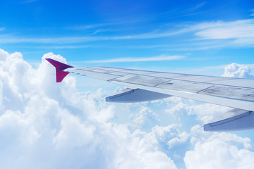 wing of airplane flying above clouds