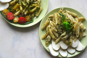 Pasta penne with pesto fresh homemade sauce and cherry and basil. 