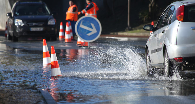 Voitures passant dans une rue inond&eacute;e	