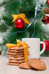 festive cookies and a white cup on a background of a decorated Christmas tree, christmas background, new year 2020