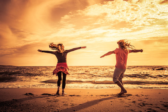 Gl&uuml;ckliches Paar am Strand bei sonnenuntergang