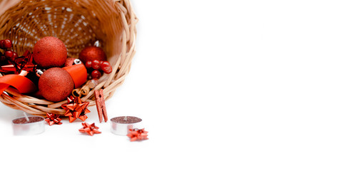 Basket with new year decorations, christmas balls, bow and red confetti stars. Holiday concept top  horizontal view. Sale and banner background.