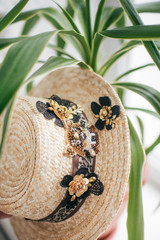 Beautiful straw boater decorated with a brooch in green leaves