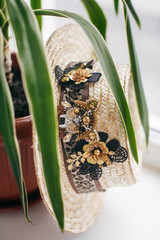Beautiful straw boater decorated with a brooch in green leaves
