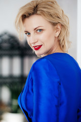 Fototapeta premium Portrait of beautiful young blonde woman with makeup in fashion blue clothes