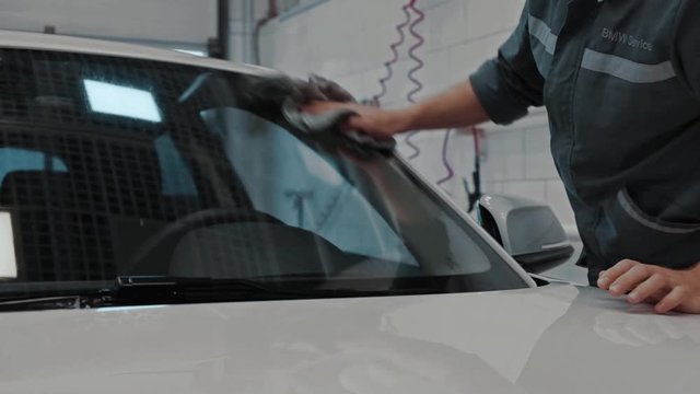 Wipes water on car at service