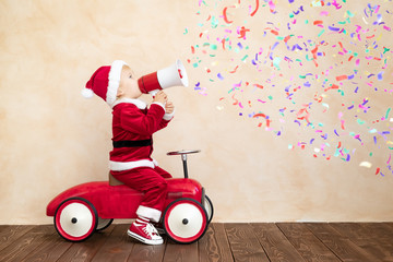 Happy child dressed Santa Claus costume playing at home