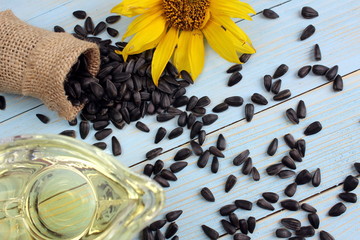 overturned small bag with sunflower seeds with a yellow flower on a background