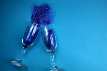 on a blue background from two glasses sparkles scattered