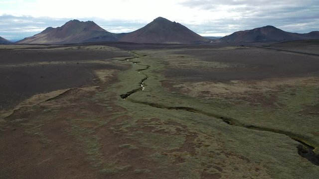 Aerial footage of a thin stream cutting through the Icelandic countryside