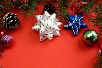 Christmas texture fir branches, toys and cones on a red background