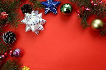 Christmas texture fir branches, toys and cones on a red background
