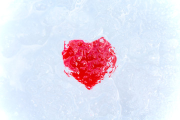 Red heart in ice. Close-up. Background. Texture.