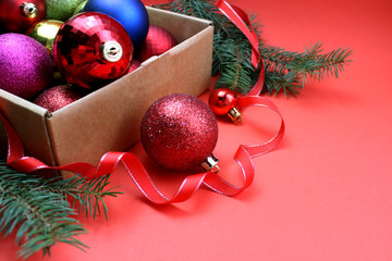 box with Christmas toys stands on a red background