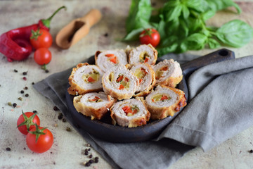 Pieces of meatloaf with cheese and pepper on a wooden plate