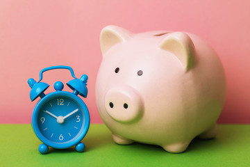 Alarm clock and piggy bank close-up. Time to save money