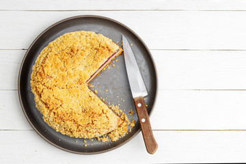 Homemade cherry pie with crumbs on top on white wooden table. Top view. Copyspace.