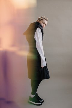 Surreal portrait of woman in monochrome clothes and bright colorful blur