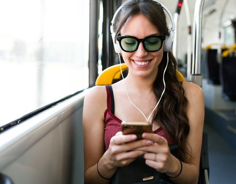 Smiling woman using phone in bus