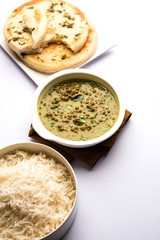 Black Masoor Dal fry or Dhaba Style Sabut Red Lentil dhal tadka in green curry, served in a bowl. selective focus