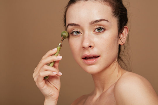 Stunning Woman using Jade Roller