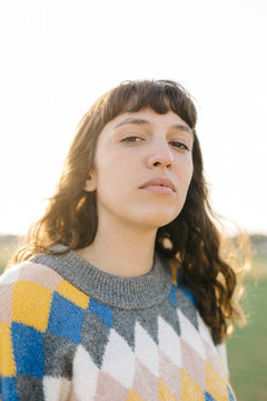 Young woman in colorful sweater in sunlight