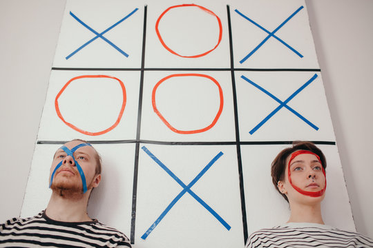 Couple on board with noughts and crosses