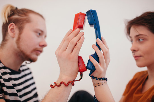 _ouple holding telephone receivers close