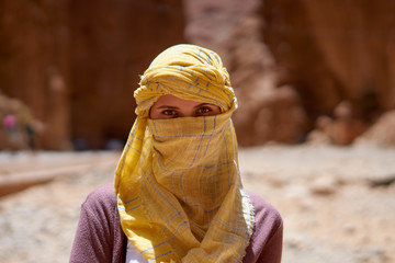 Portrait of the female traveler with a tied yellow berber tagelmust scarf. 