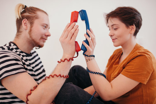 _ouple holding telephone receivers close