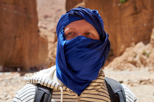 Portrait of the traveller with a tied blue berber tagelmust scarf, Atlas Mountains in Morocco.       