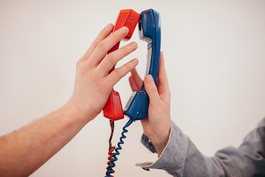 _ouple holding telephone receivers close