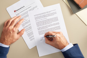Crop businessman signing paper