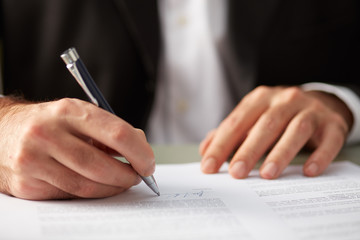 Faceless man putting signature