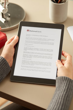 Crop woman reading contract on tablet