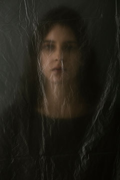 Woman behind blurry plastic