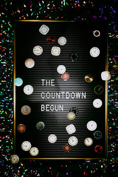 Many elegant clocks on top of letter board spelling The countdown begun