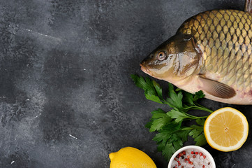 Raw carp on a dark surface. View from above. Close-up. Free space for text. Products concept for the festive table.