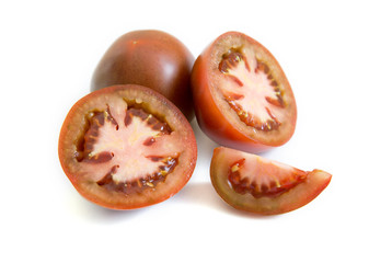 Dark red tomatoes Kumato variety isolated on white background.