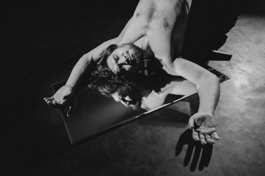 A man lying over the mirror.
