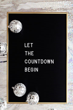 Board letter saying Let the countdown begin and silver disco balls