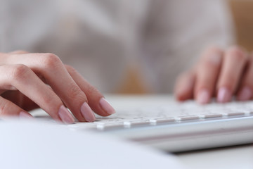 Female hands typing on silver keyboard using computer pc at workplace closeup. White collar job digital shopping office lifestyle search success enter login password and credentials concept