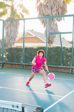 An active mature woman in action on the platform tennis court.