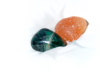 Two large stones on white background, quartz and polished jade.