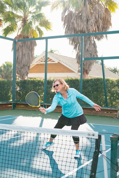 An active senior woman playing platform tennis.