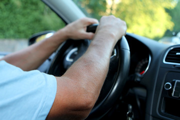 driver sitting at the wheel of a car, close-up, copy space