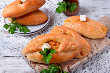 Rasstegai pie of yeast dough with meat filling on white wooden table. Traditional meal of Russian cuisine © kcuxen