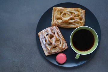 Coffee cup and apple pies on a dark background. Coffee mood.