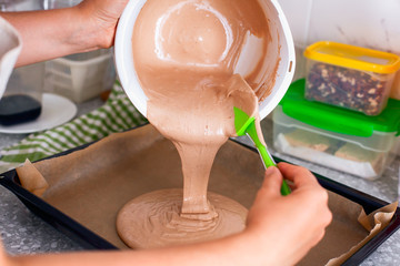 Woman hands putting dough on baking tray.